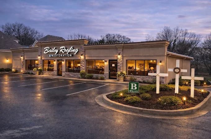 The Bailey Roofing & Restoration front office in Buford at dusk, sign lit and crosses out front
