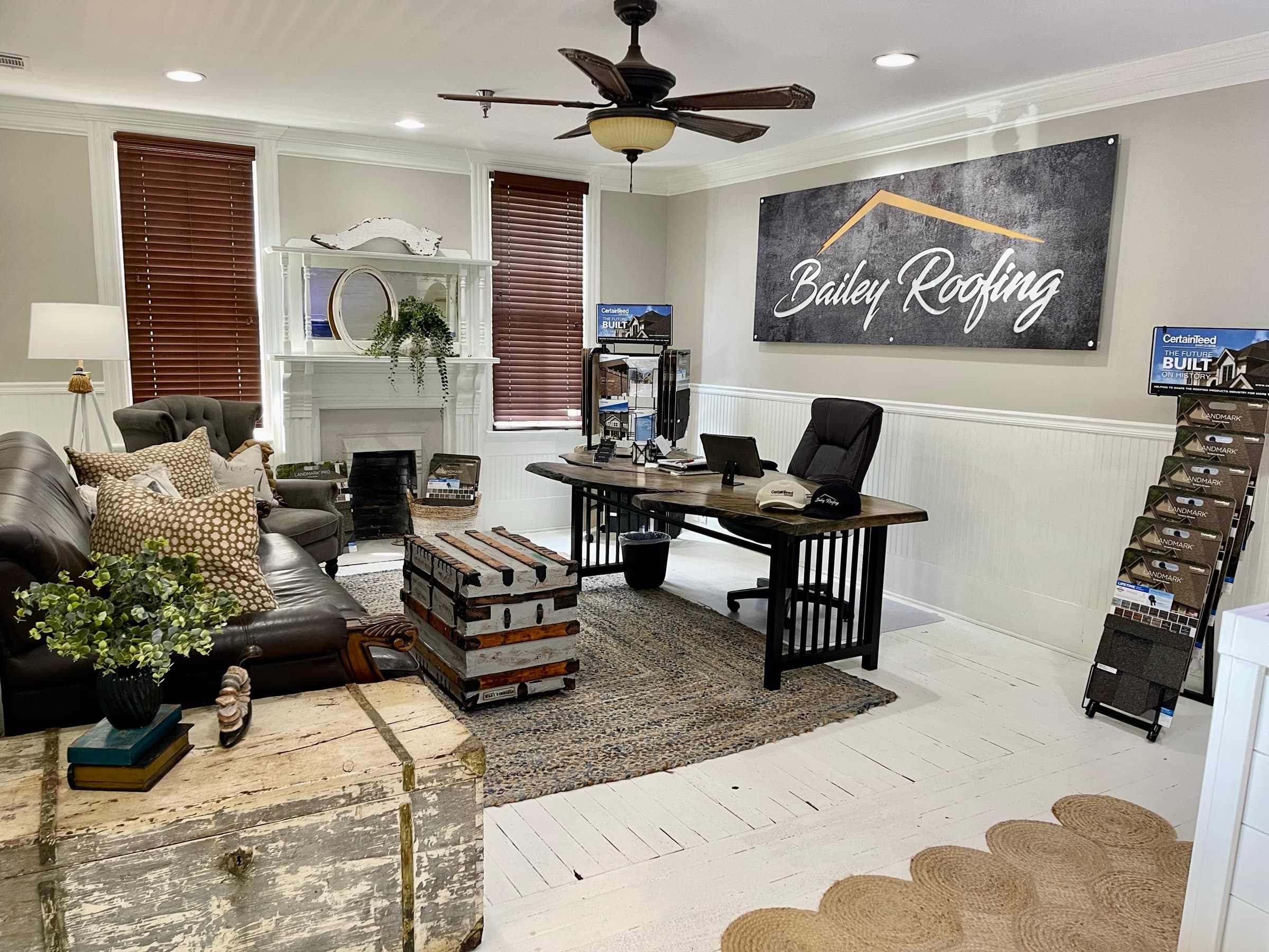 The Bailey showroom lounge — leather seating, fireplace, and CertainTeed shingle displays